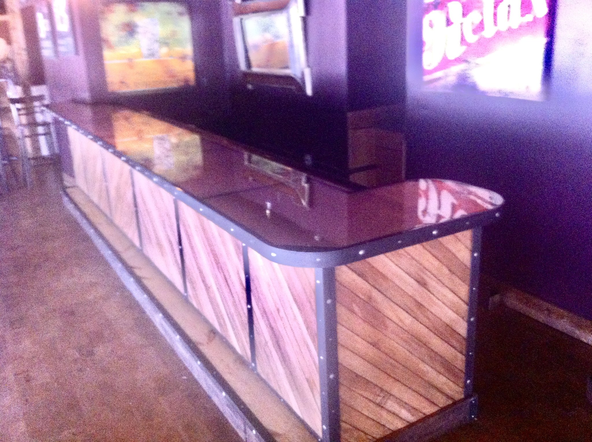 Commercial bar build with dark gloss top and custom wood panel front