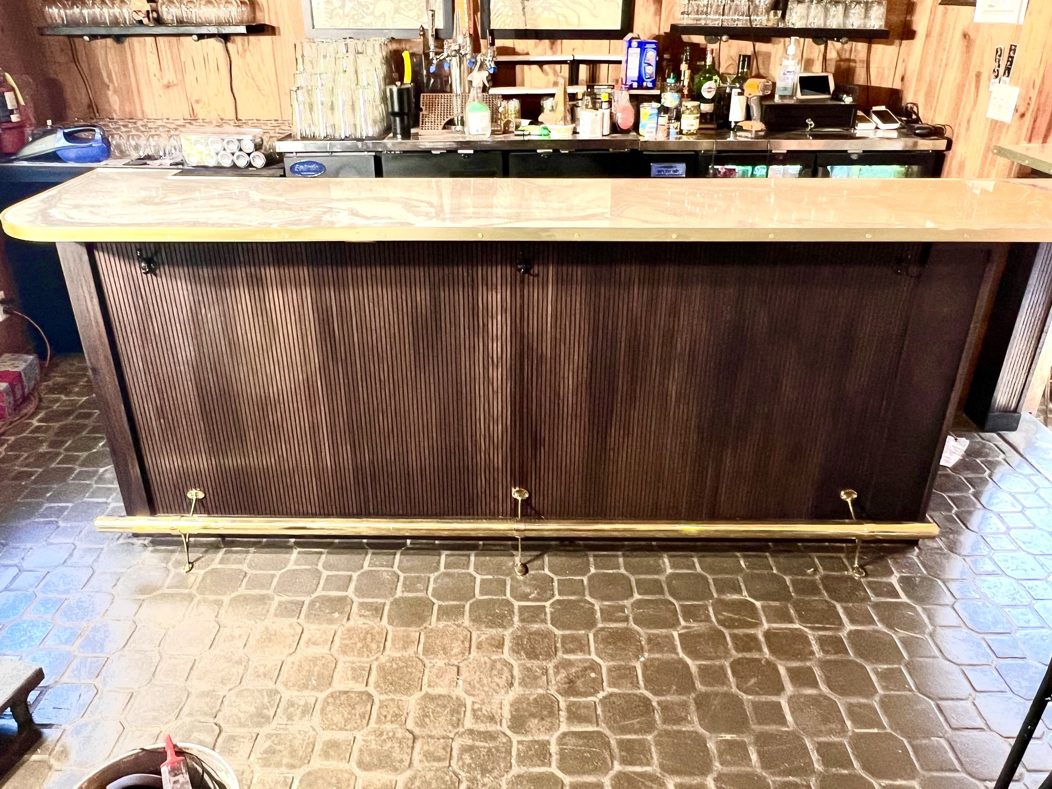 Custom bar build at Haiku I Do — ribbed panel bar front with brass foot rail