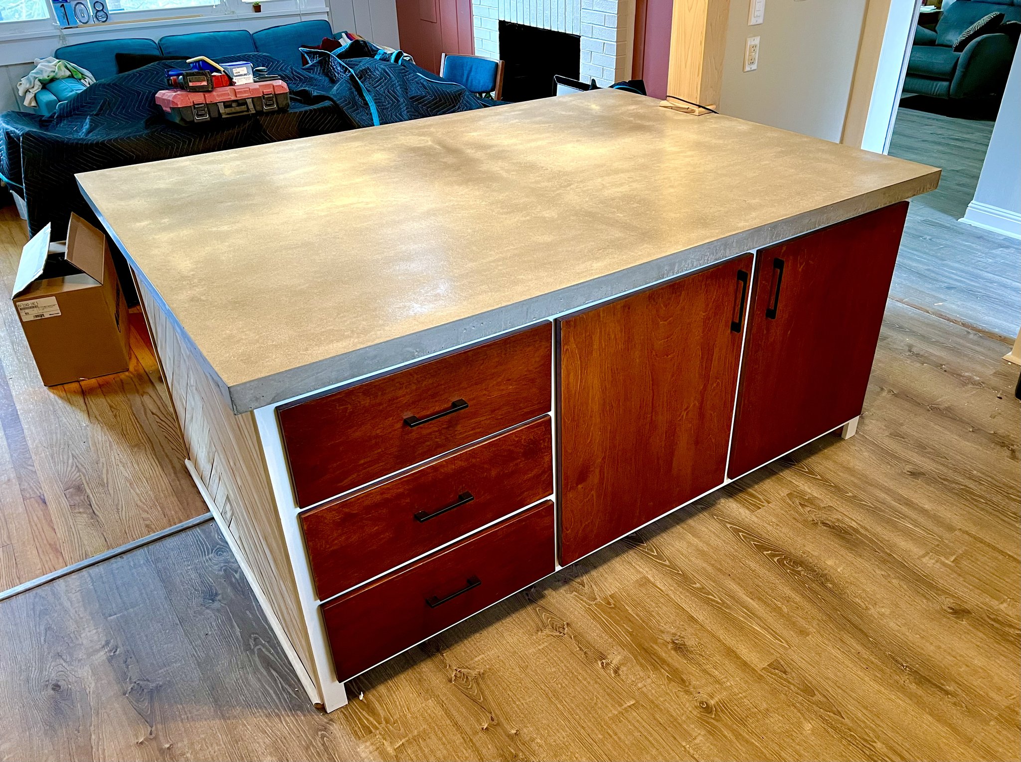 Kitchen island with cast concrete countertop over cherry cabinet base