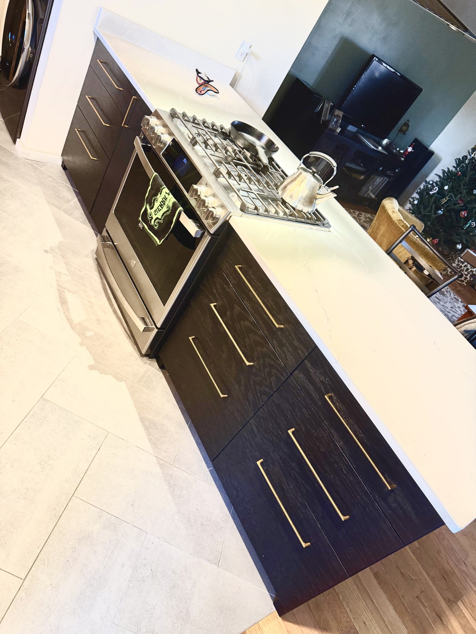 Residential kitchen with red oak cabinetry in ebony finish and brass hardware