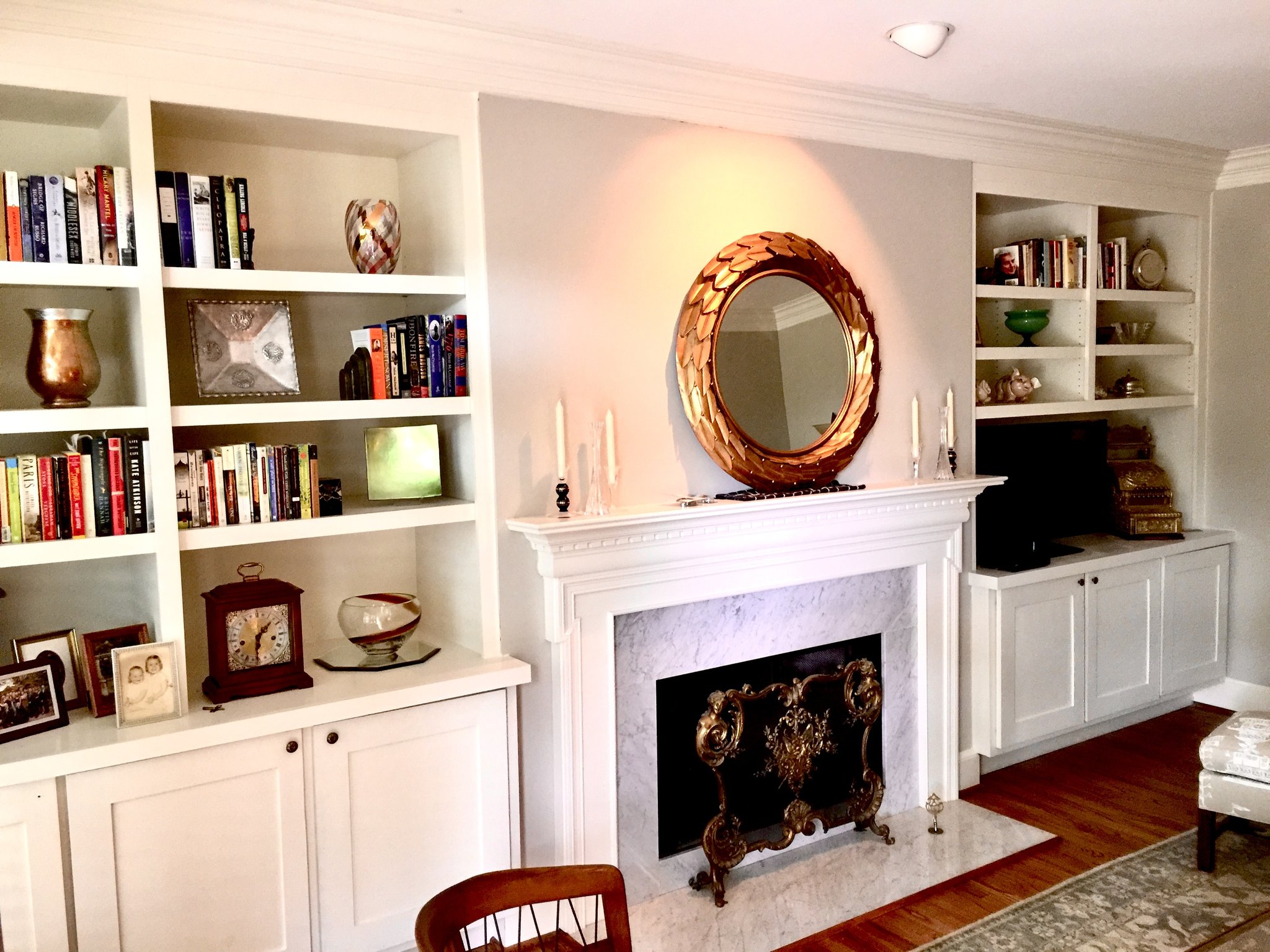 Painted residential built-ins with compound crown molding flanking a marble fireplace — finish carpentry by MTR