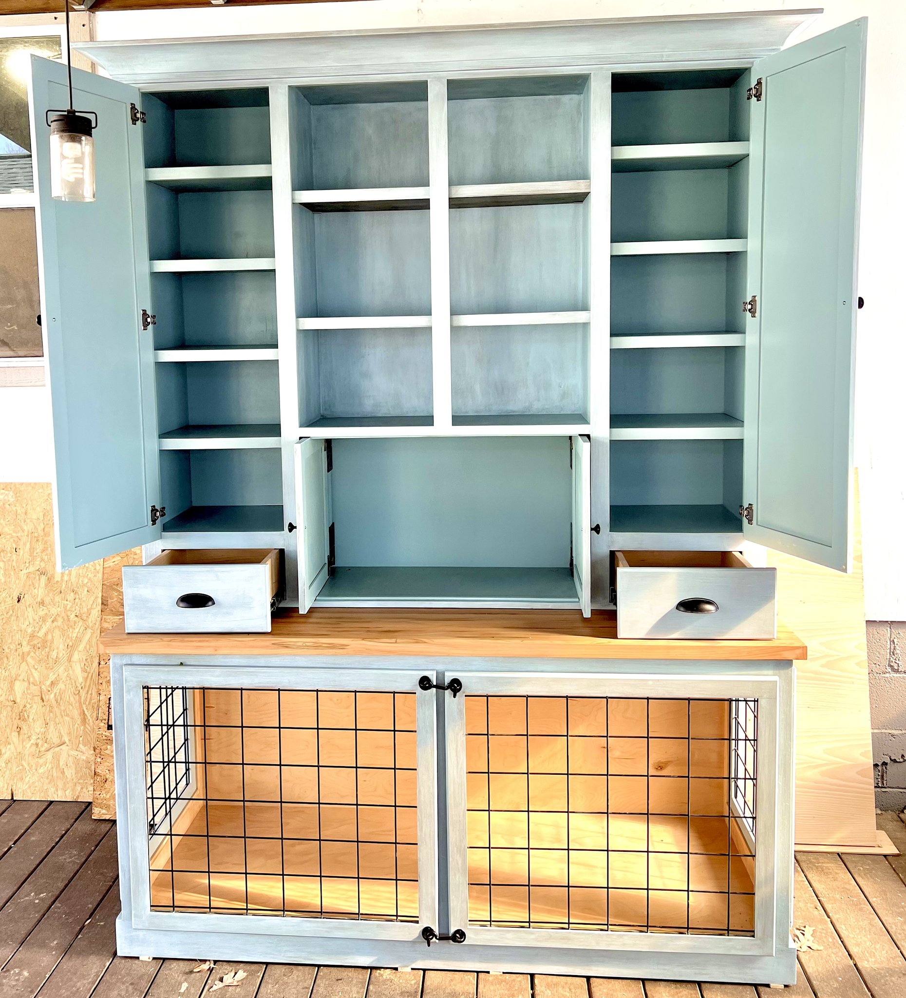 Custom antique-painted dog hutch — built-in cabinet with dog crate base and wire mesh doors