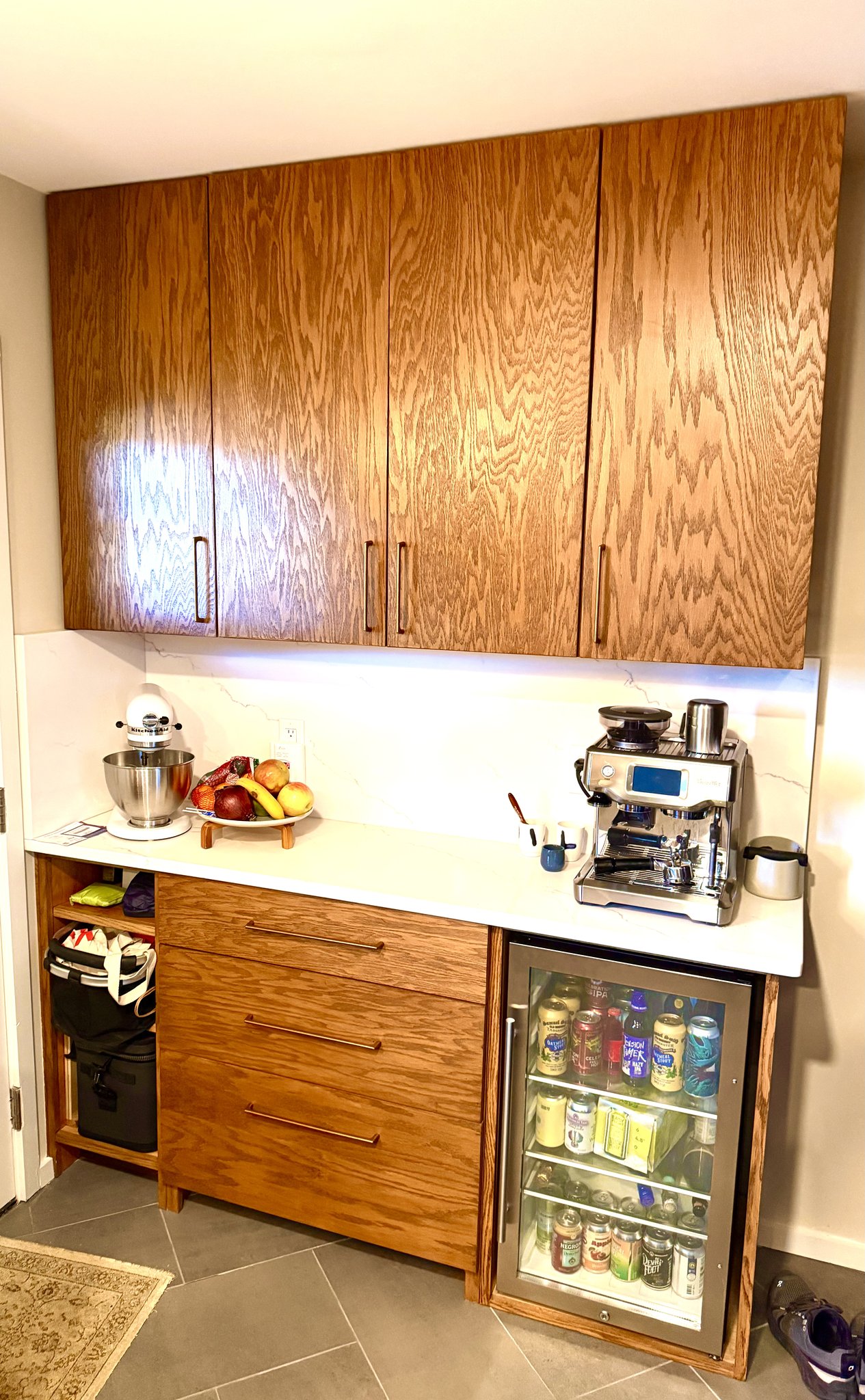 Custom red oak kitchen cabinetry in antique oak finish with integrated beverage fridge