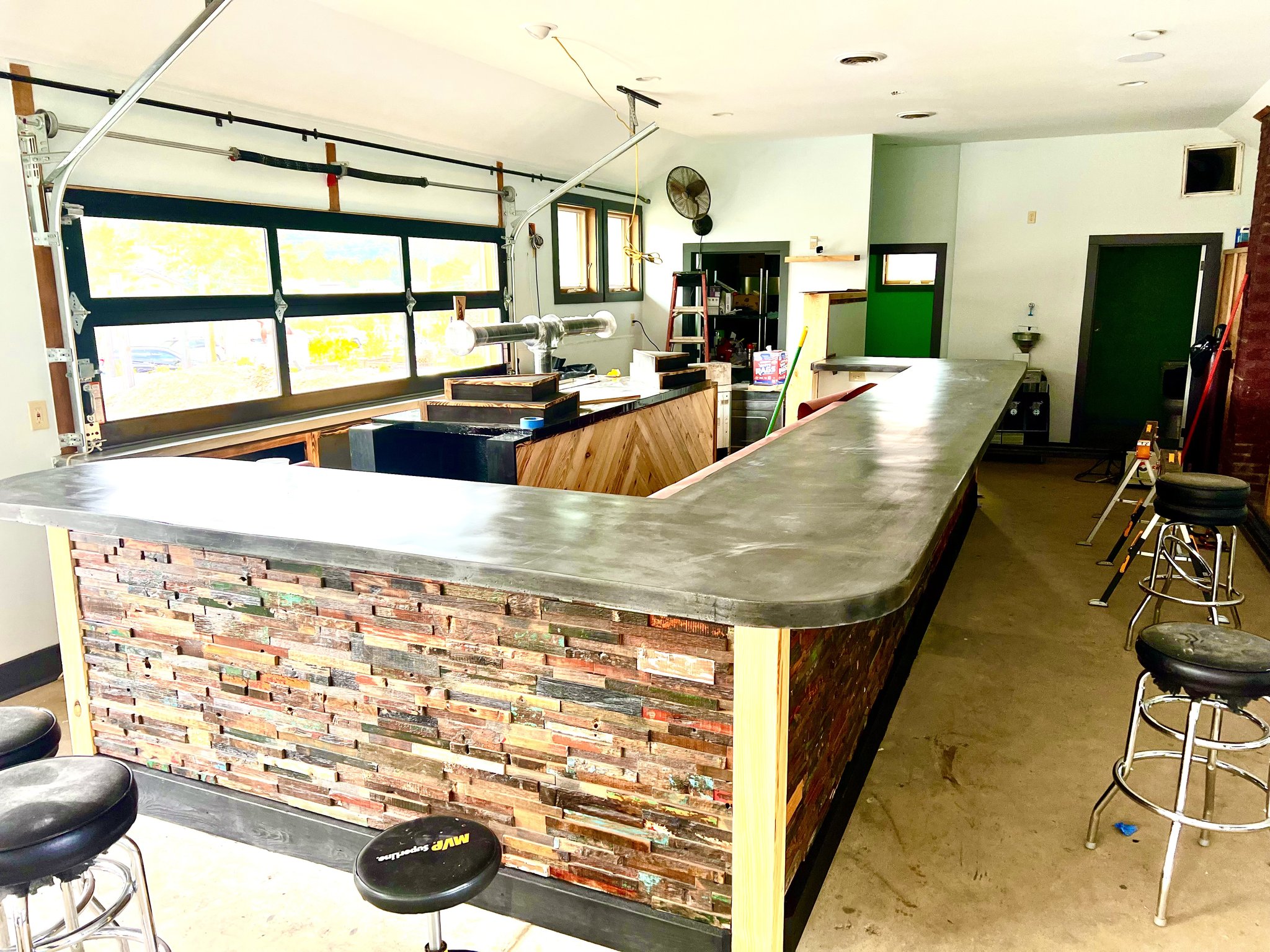 Full bar and millwork build-out at Foothills Grange, Black Mountain NC — concrete bar top with reclaimed wood panel face